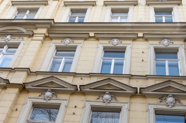 Klasik pencereleri ve mimari detayları olan tarihi bir Avrupa binasının cephesi.