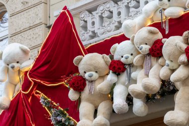 Noel süslemeleri olarak kırmızı gülleri olan oyuncak ayılar.