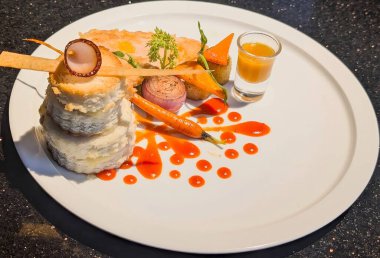 Beautifully plated gourmet chicken breast served with roasted root vegetables, creamy sauce, and artistic garnish.