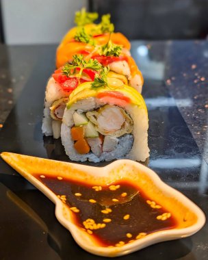 Close-up of sliced sushi rolls filled with fresh vegetables, seafood, and rice wrapped in seaweed. The image showcases vibrant colors, rich textures, and a clean minimalist composition.