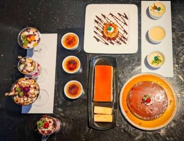 An elegant assortment of gourmet dishes including soups, rice bowls, appetizers,and savory entres served on a red tablecloth.