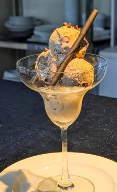 Zarif bir bardakta sunulan zengin çikolatalı dondurma kepçeleri gevrek bir gofret çubuğu ve çikolata parçacıklarıyla süslenmiş..