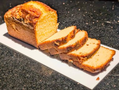 Ilık ışık altında parlak tabaklarda sergilenen zengin çikolata katmanlı altın mermer somun kekleri. Nemli doku ve zarif sunum onu fırın menüleri için ideal hale getiriyor..