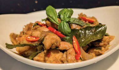 Tayland fesleğenli tavuk kızartması. Kırmızı biber, soğan ve kokulu fesleğen yapraklarıyla pişirilmiş taze tavuk parçaları..