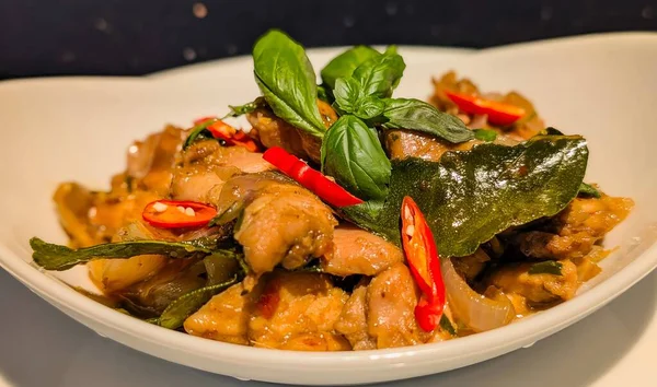 Tayland fesleğenli tavuk kızartması. Kırmızı biber, soğan ve kokulu fesleğen yapraklarıyla pişirilmiş taze tavuk parçaları..