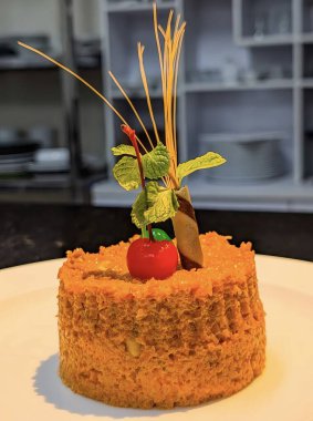 Kaplama kiraz, nane yaprağı ve dekoratif çikolata çubuğuyla süslenmiş güzel kaplamalı geleneksel gajar halwa (havuç pudingi)..