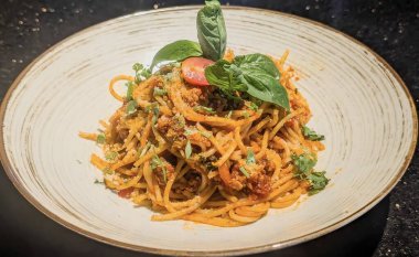 Klasik Spagetti Bolonez 'in davetkar yakın çekimi. Bol miktarda kırmızı domates sosu ve yanında mükemmel pişirilmiş sarı spagetti..