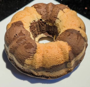 Altın vanilya ve zengin kahverengi çikolata aromalı güzel bir girdap desenli mermer kekin baştan çıkarıcı genel manzarası..