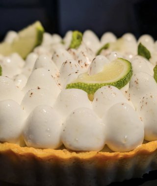 Görsel olarak göz kamaştırıcı, klasik limonlu turta. İçinde altın hamur kabuğu ve uzun, parlak tepeler var..