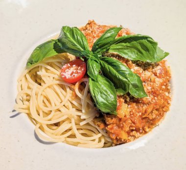 Klasik Spagetti Bolonez 'in davetkar yakın çekimi. Bol miktarda kırmızı domates sosu ve yanında mükemmel pişirilmiş sarı spagetti..