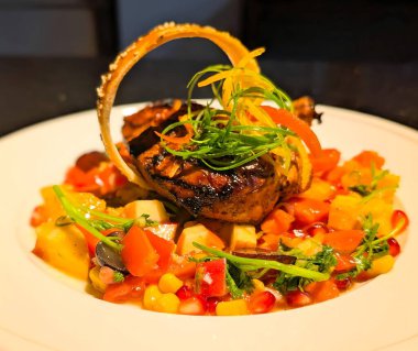 Bir gurme et yemeği, kızarmış tavuk veya domuz eti ile sanatsal olarak kaplanır, narenciye kabuğu ve taze otlarla süslenir..