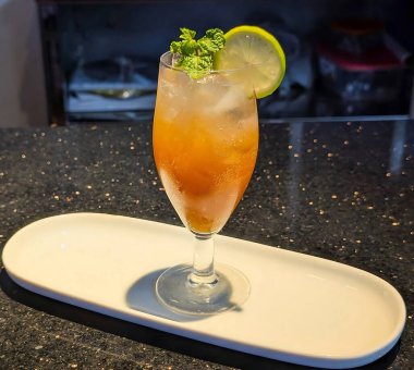 Zarif kadehlerle servis edilen turunçgil kokteylleri, canlı renklerle kaplı ve limon dilimleri ve taze nane ile süslenmiş..