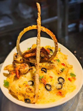 Eritilmiş peynir, ızgara karides, siyah zeytin ve doğranmış dolmalık biberli gurme fırında makarna güveci..