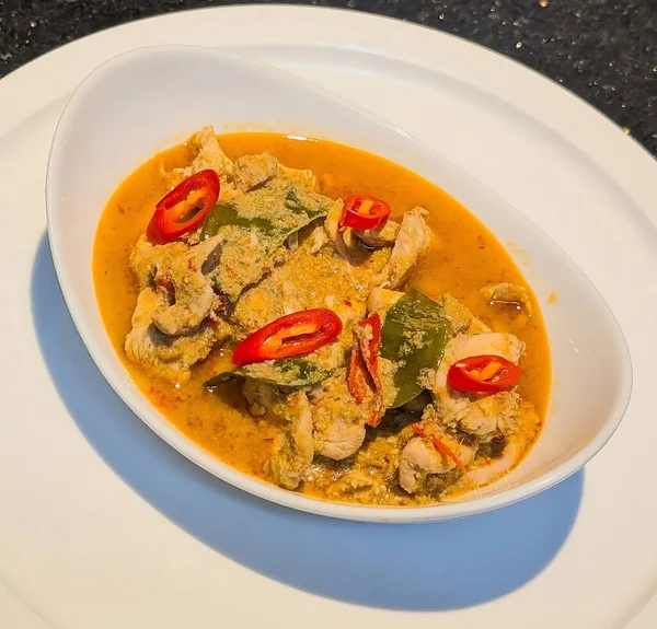 Bu geleneksel Tayland Panang tavuğu köri sosu kaffir limon yaprakları ve taze kırmızı biberle süslenmiş zengin, kremalı hindistan cevizi soslu taze et içerir..