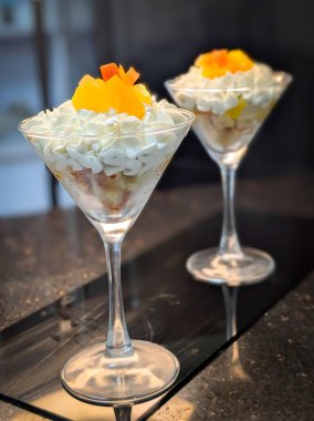 Krem şanti, pasta ve taze şeftali dilimleriyle servis edilen zarif katmanlı meyve tatlısı..