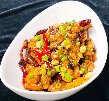 Klasik Kung Pao tavuğu, doğranmış tavuk, kavrulmuş fıstık, kurutulmuş kırmızı biber, yeşil soğan ve baharatlı soslu susam tohumu..