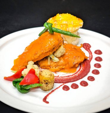 Yeşil fasulye, karnabahar, fırında patates ve kırmızı biber ve sanatsal sos ile bitirilmiş puf böreğiyle birlikte ağır ateşte pişirilmiş protein..