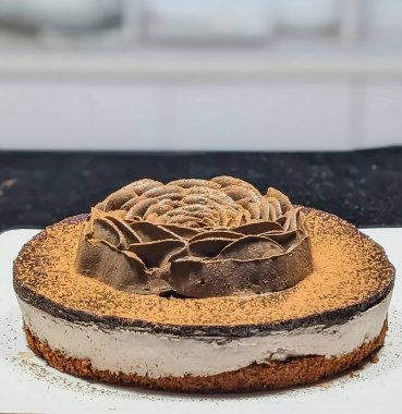 Süslü çikolata kaplı kremalı pasta ve kakao tozlu üstü dekoratif çikolata çiçeğiyle bitirilmiş kremalı dokular ve katmanlı yapılar..