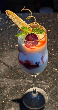 Vanilyalı krema, karışık böğürtlen ezmesi ve kek parçaları ile kaplı, karamel şekeri, gofret ve taze nane ile bitirilmiş gurme meyveli parfe..