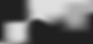 İnce bir tahıl dokusuna sahip soyut siyah-beyaz gradyan. Karanlık ve aydınlık bölgeler arasındaki yumuşak geçişler ince bir atmosferik etki yaratır..