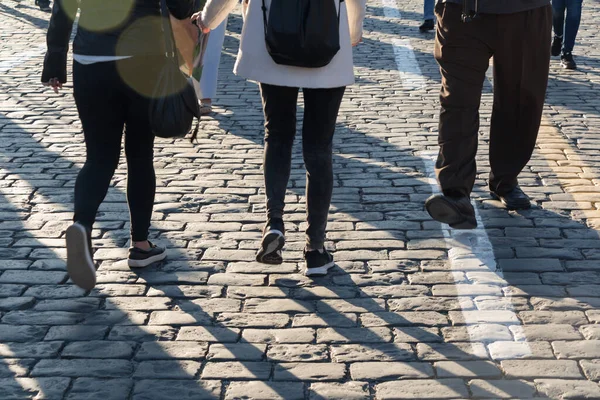 Pedestrians on cobblestone pavement, shadows, people traffic