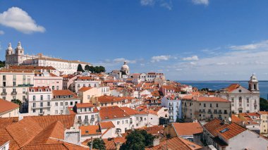 Portekiz, Lizbon 'daki Alfama ve Saint Stephen Kilisesi' ne Tagus nehri ve açık bir gökyüzünün altında feribot manzarası.