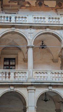 Kemer, balkon ve eski cephe detaylarıyla tarihi taş bina. Mimarlık geçmişi ya da kültürel miras kavramı için mükemmel..