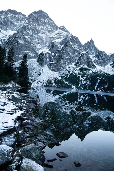 Höga Steniga Berg Täckta Med Snö Reflektera Svart Sjö Vackert — Stockfoto