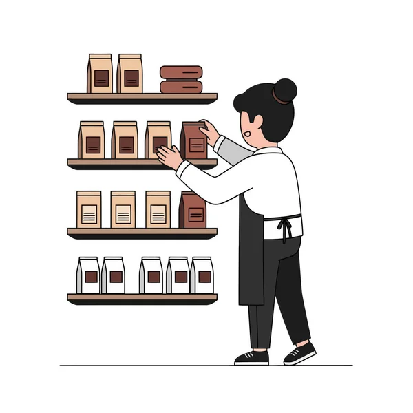 Barista modern bir kafenin içindeki raflara kahve poşetleri koyuyor.