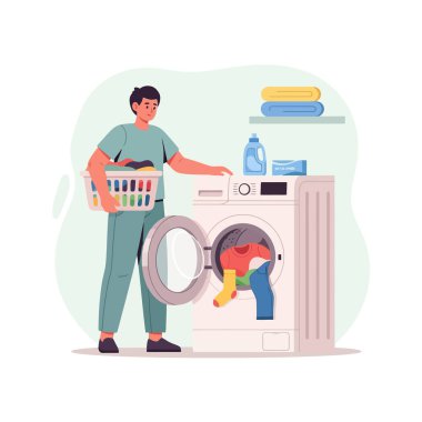 Çamaşır makinesi ve çamaşır sepetiyle evde çamaşır yıkayan bir adam.