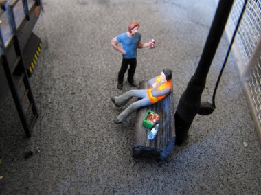 İşçiler bir bankta mola verip sohbet ediyorlar.