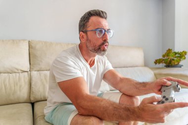 Başlık: Yoğun Orta Çağ Adamı Evde Koltukta Otururken Video Oyunları Oynamaya Odaklandı