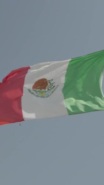 Meksika bayrağı mavi gökyüzüne karşı gün batımında dalgalanıyor