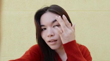 Genç Japon kadın farklı duyguları ifade ediyor ve farklı yüz ifadeleri takınıyor. 