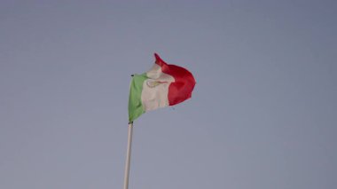 Meksika bayrağı mavi gökyüzüne karşı gün batımında dalgalanıyor