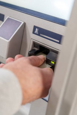 Bankamatiğe kredi kartı sokan bir iş adamının banka işlemleri sırasında para çektiği görüntüler.