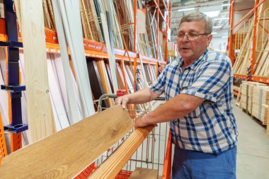 Son sınıf öğrencisi bir hırdavatçıda plastik döşeme seçiyor.