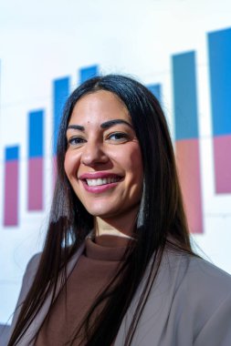 Finansal büyüme grafiğini sunan profesyonel iş kadını, kurumsal sunum sırasında kendine güvenen bir gülümseme sergiliyor