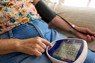 Tansiyonu evde ölçülen tanınmamış yaşlı kadın. Evde Kan Basıncını Ölçen İspanyol Yaşlı Kadın SağIık ve Sağlık İçin Dijital İzleyici Kullanıyor.