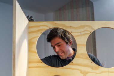 Orta yaşlı İspanyol marangoz, marangozhanesinde bir mobilya montajında çalışıyor.