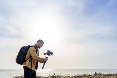 Kamera Operatörü Sel Hasarlı Bitkiler ve Enkaz Ashore 'u Gimbal kullanarak Plajda Yıkadı