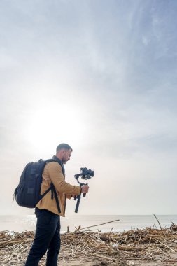 Videograf sahilde meydana gelen sel felaketini belgeliyor, enkazı ve kirliliği yakalıyor ve kıyıya vuruyor.
