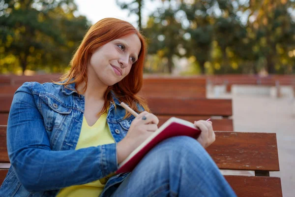 Genç bir kadın bir deftere yazarak yaratıcılığını ve ilhamını ifade ediyor.