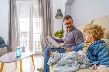 Evde yaşayan, ateşli çocuğa bakan, uzaktan çalışan, ebeveynlik desteği ve kariyer taleplerini dengeleyen profesyonel bir baba.
