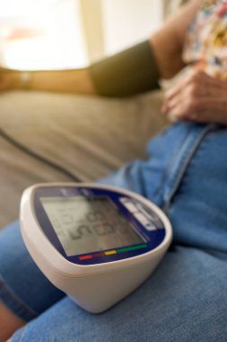 Tansiyonu evde ölçülen tanınmamış yaşlı kadın. Evde Kan Basıncını Ölçen İspanyol Yaşlı Kadın SağIık ve Sağlık İçin Dijital İzleyici Kullanıyor.