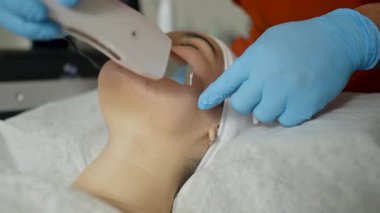 Güzellik salonundaki kadın yüz ameliyatı yapıyor.