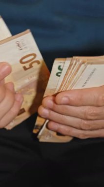50 avroluk banknotlarla ilgilenen işadamı, kapalı bir ortamda mali işlemleri ve nakit yönetimini gösteriyor