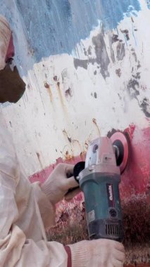 Hareketli bir tersanede, yetenekli eller, eski boyaları bir gemi gövdesinden çıkarmak için özenle çalışırlar..