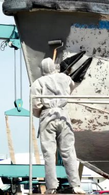 Becerikli işçiler geminin kenarlarını özenle boyarlar, tersanede işçiliklerini sergilerler. Endüstriyel arkaplan ile canlı renkler karşıtlığı, deniz bakımında yer alan sanatsallığı vurguluyor.