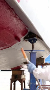 Zanaatkarlar ustalıkla geminin gövdesine canlı boya sürerek görünümünü değiştiriyorlar. İşçiler yaklaşan fırlatma için her detayın mükemmel olmasını sağladıkça tersane hareketlenmeye devam ediyor..